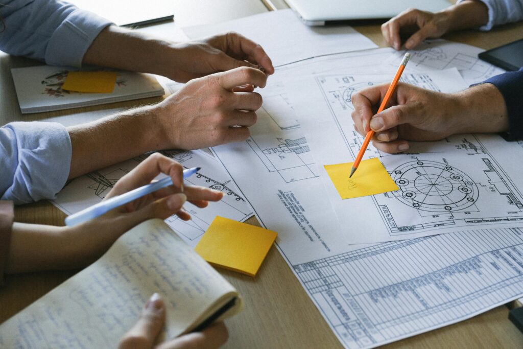 Hands drawing a strategic plan on a whiteboard, illustrating the process of creating a blueprint for actionable goals.